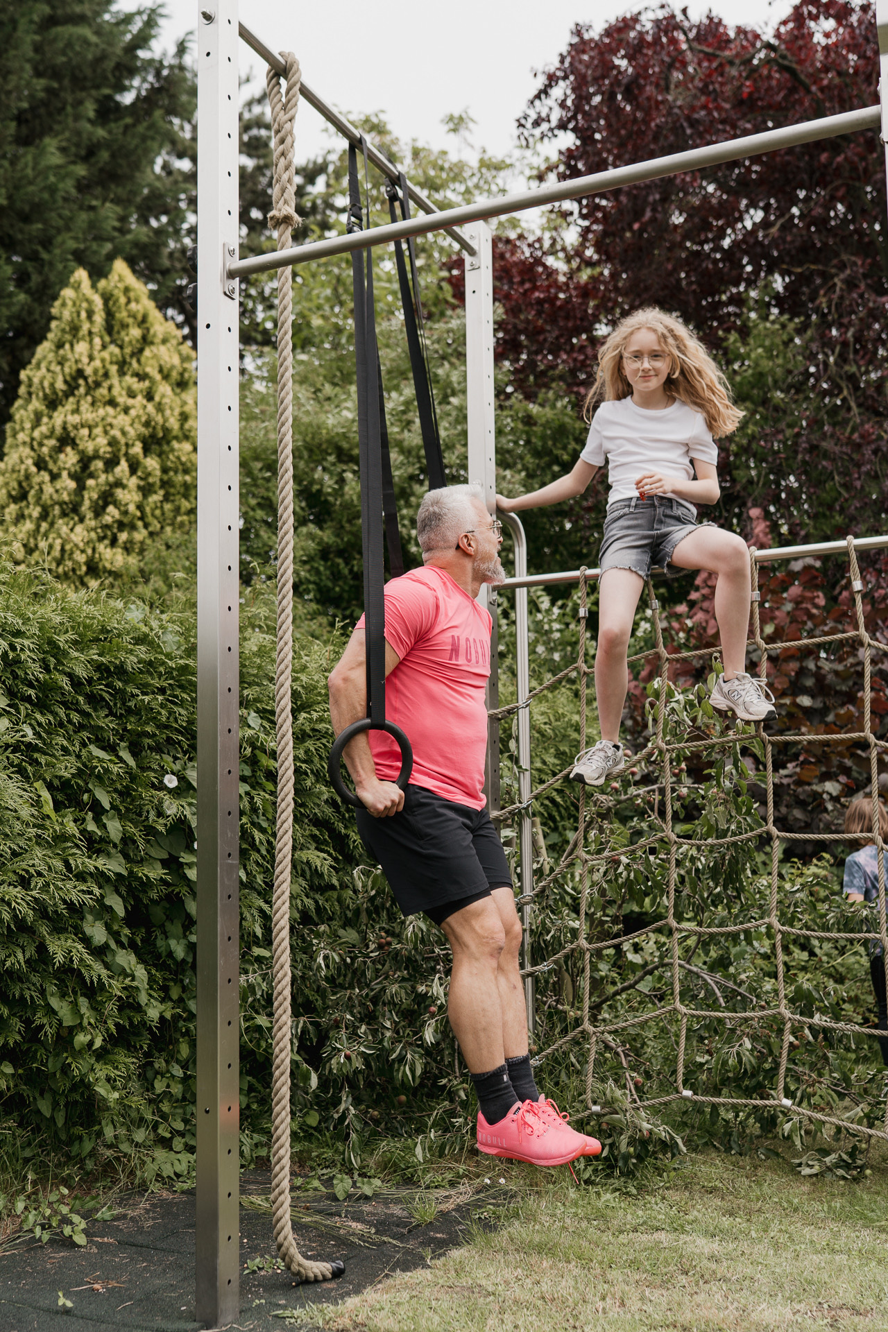 Thomas Kuballa trainiert mit seiner Tochter am Outdoor-Klettergerüst im Garten